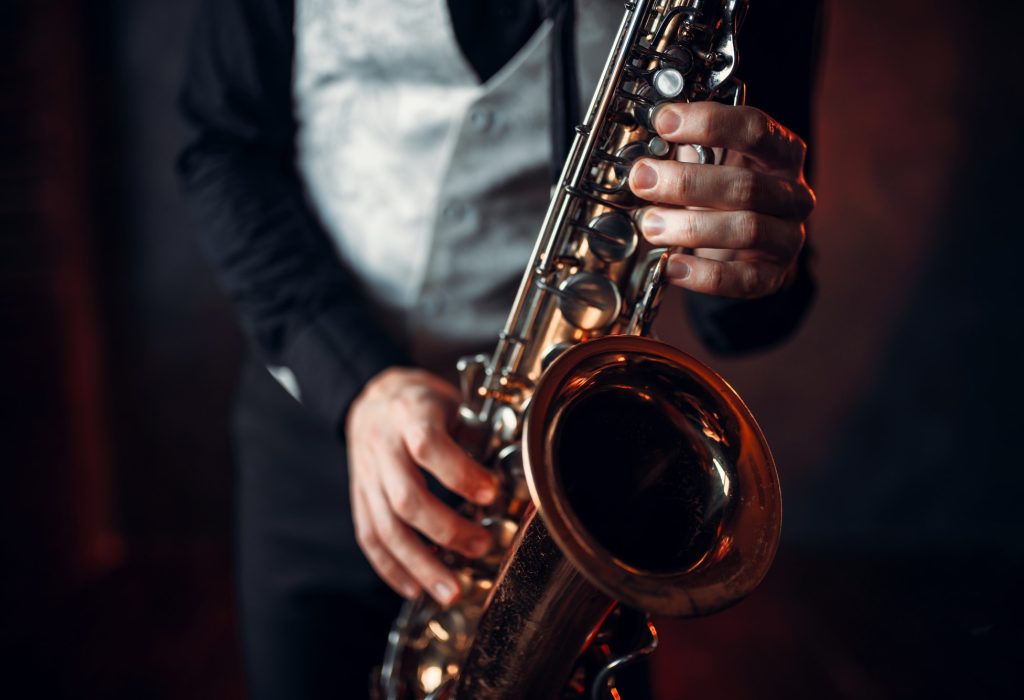 Jazz man hands holding saxophone closeup